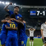 Curacao players celebrate a 7-1 football victory while Germany players look disappointed