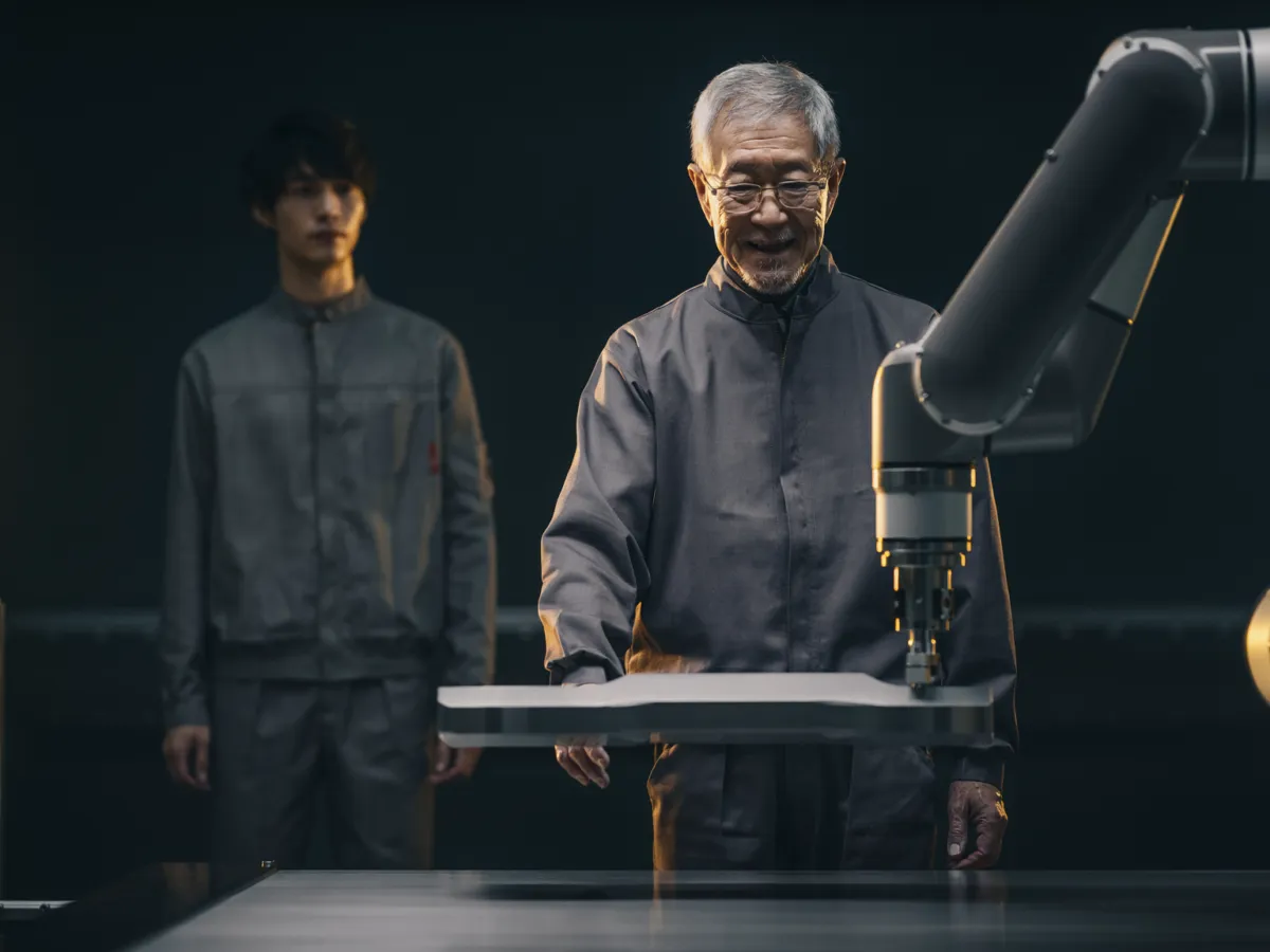 Conceptual depiction of an older engineer supervising industrial automation in an Asian factory; not a photograph of the IMF meetings.
