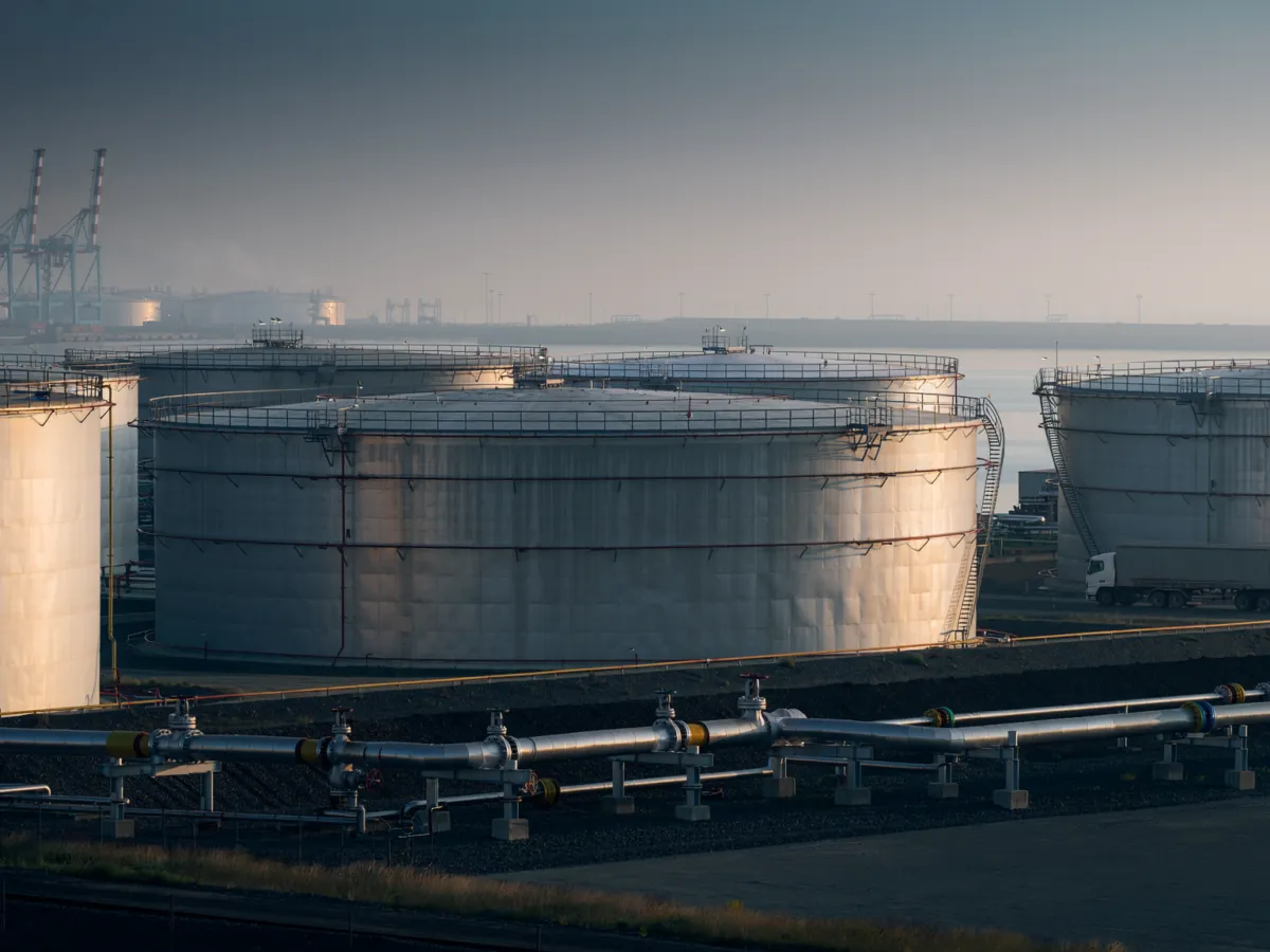 Conceptual editorial image of crude oil storage tanks and industrial piping at a Gulf Coast terminal, illustrating emergency oil supplies and freight costs.